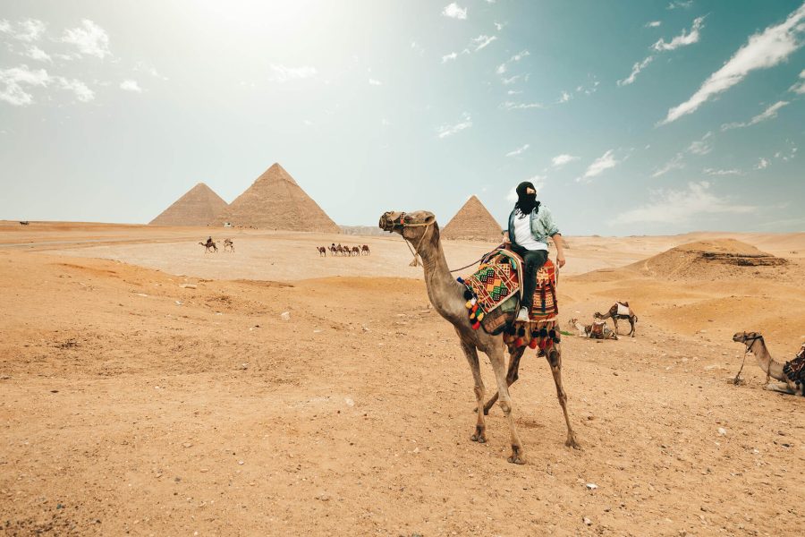 a man riding a camel in the desert